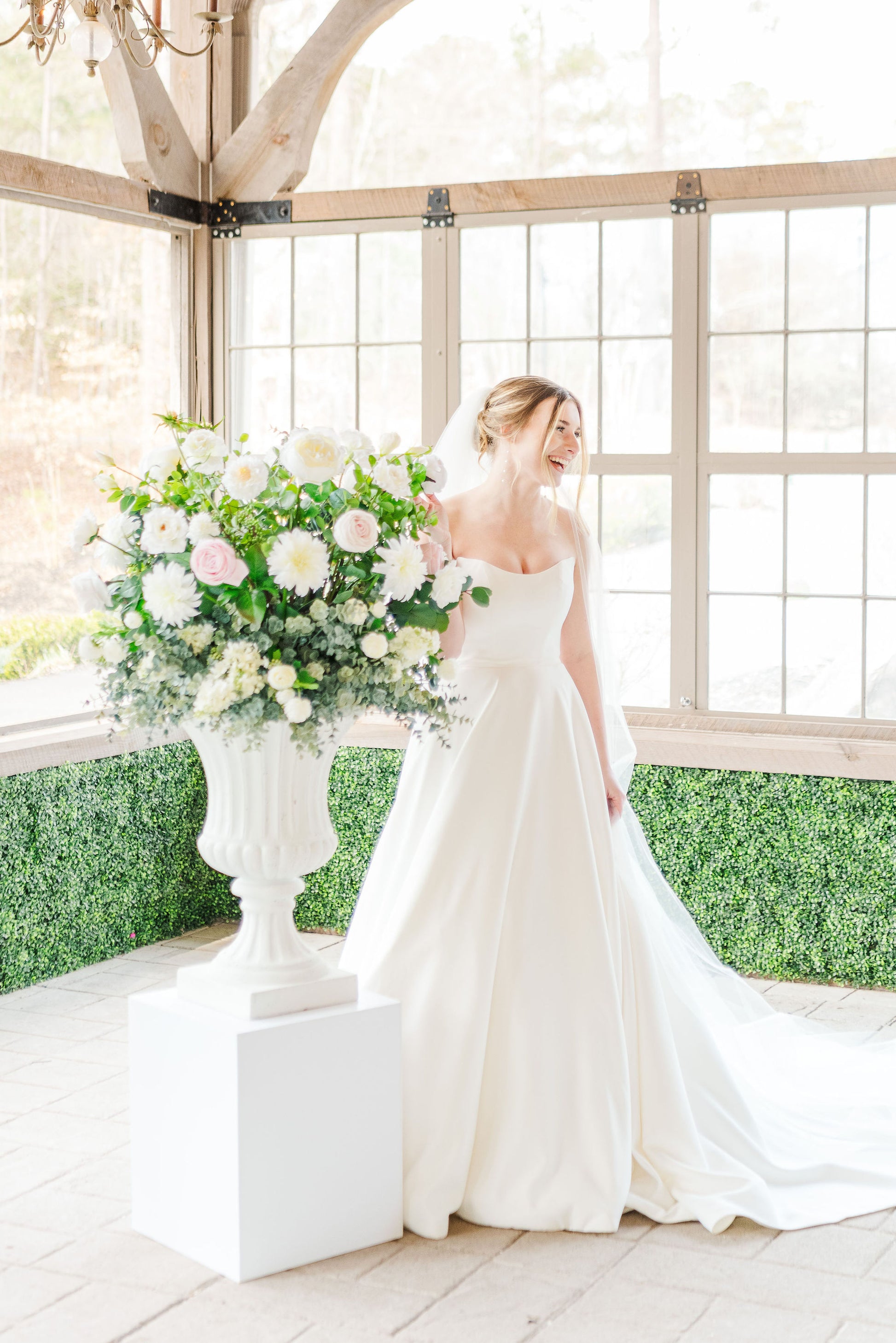 White pedestal set displayed with matching floral urns, creating a clean and elegant focal point for ceremony aisles or altar setups.