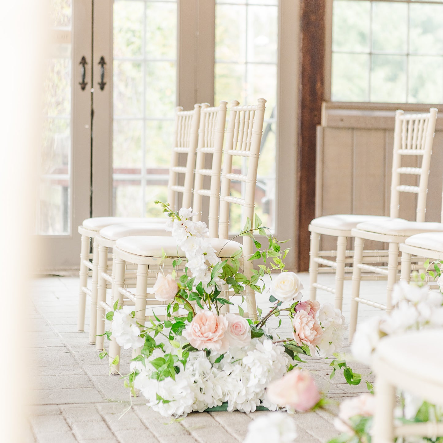 Side angle of the meadow aisle ground bouquets cascading down the ceremony aisle.