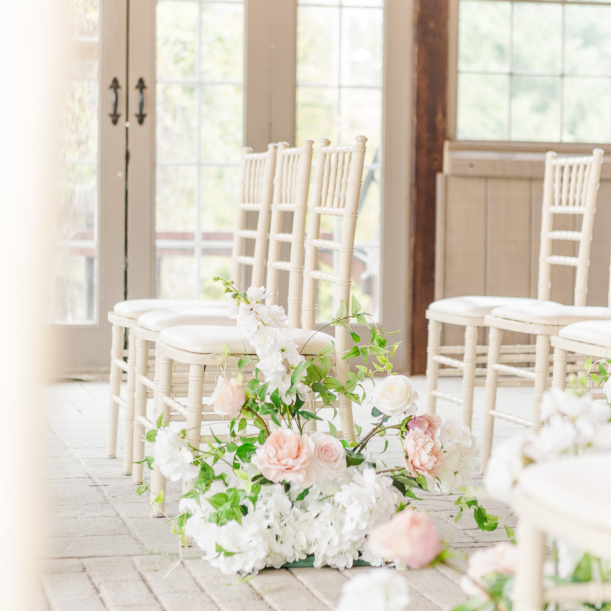 Side angle of the meadow aisle ground bouquets cascading down the ceremony aisle.