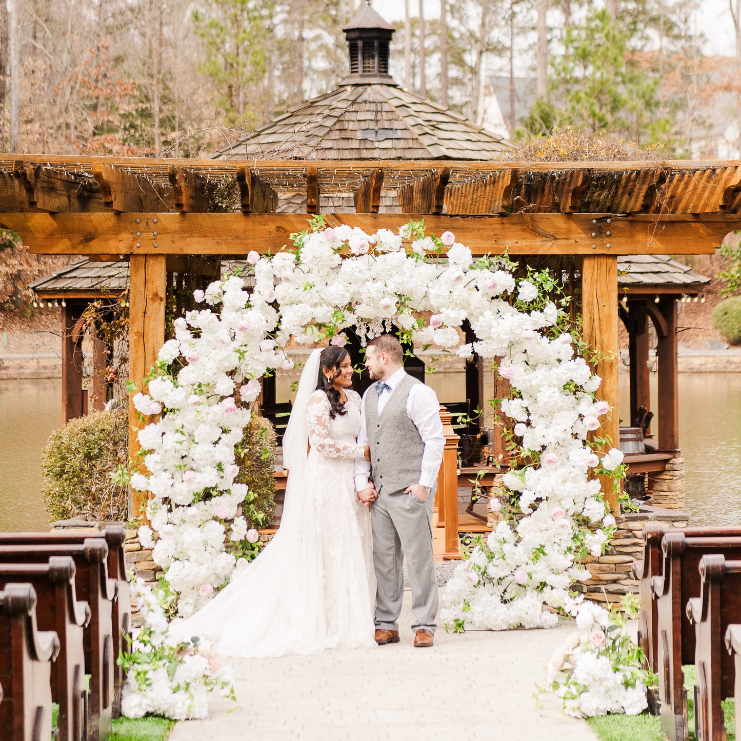 Meadow Arch glowing in golden hour light, with blush and ivory florals softly lit for a dreamy, romantic ceremony moment.