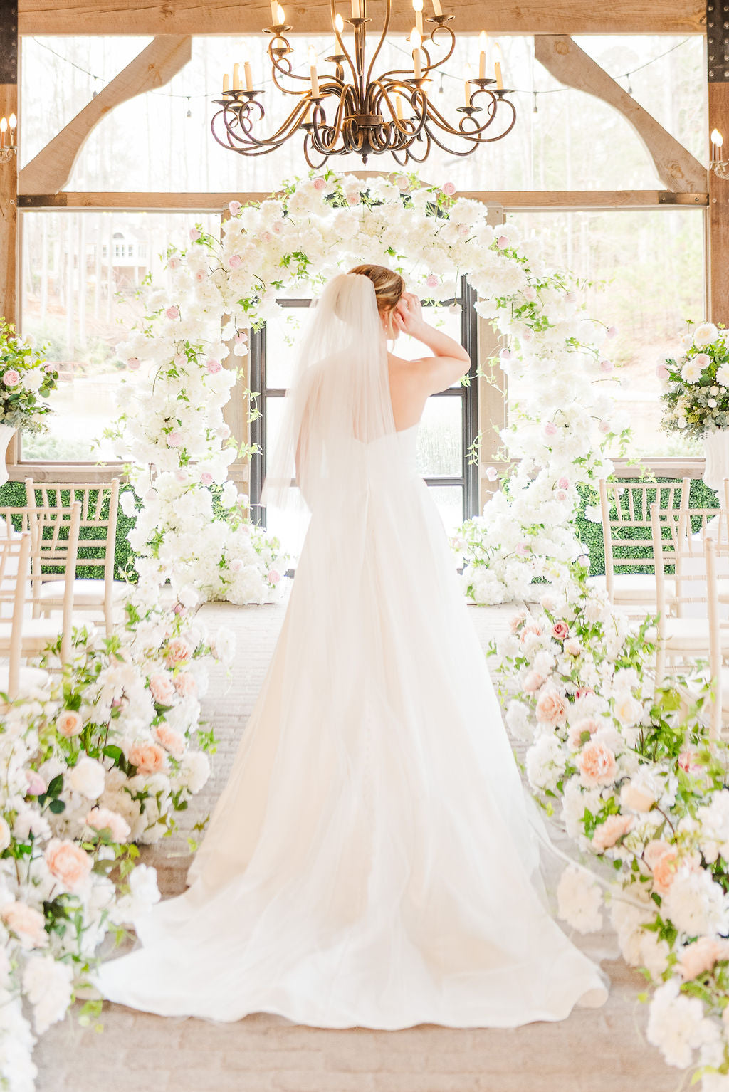 Meadow-style faux floral ground bouquet with blush and white blooms used as ceremony deocr.