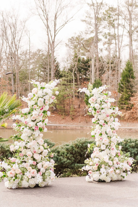 Set of two Everly floral pillars featuring soft white, dusty rose, and blush faux blooms with delicate greenery- perfect for flanking a wedding altar or aisle.