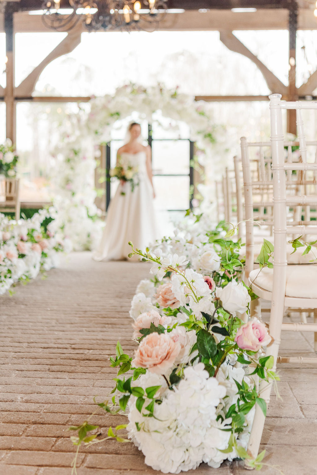 Close-up of meadow aisle bouquets lining a ceremony path, later repurposed as elegant faux floral centerpieces for reception guest tables.