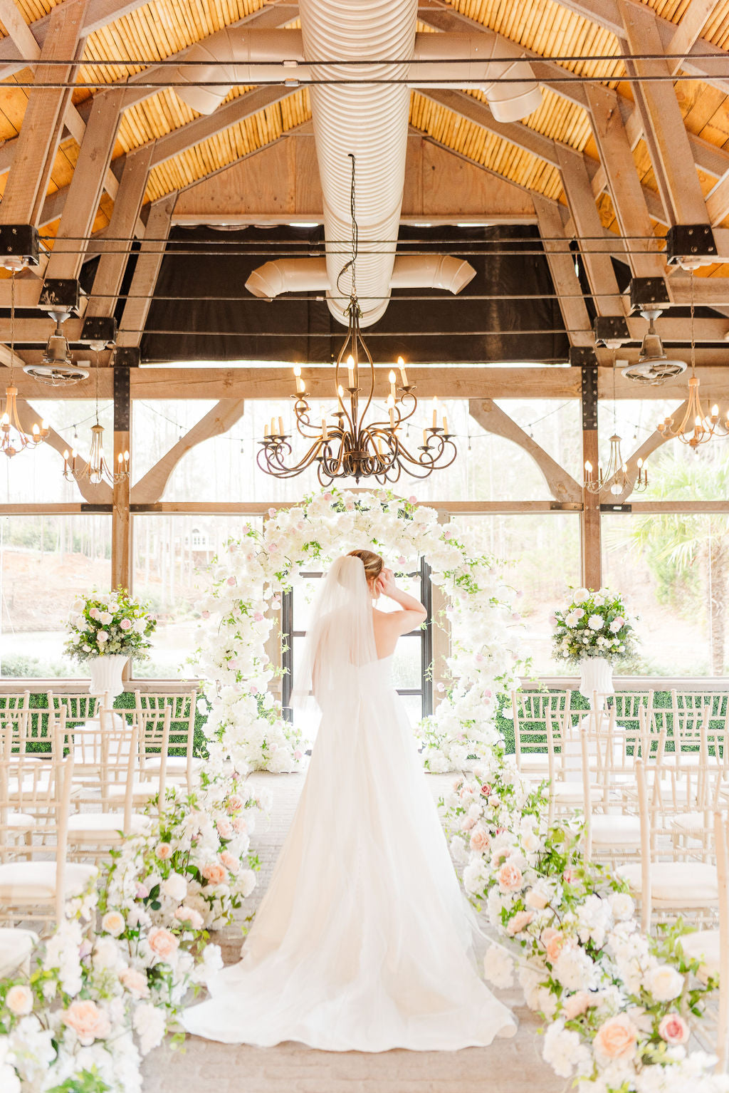 Overall view of the Meadow Arch with coordinating aisle bouquets and floral urns.