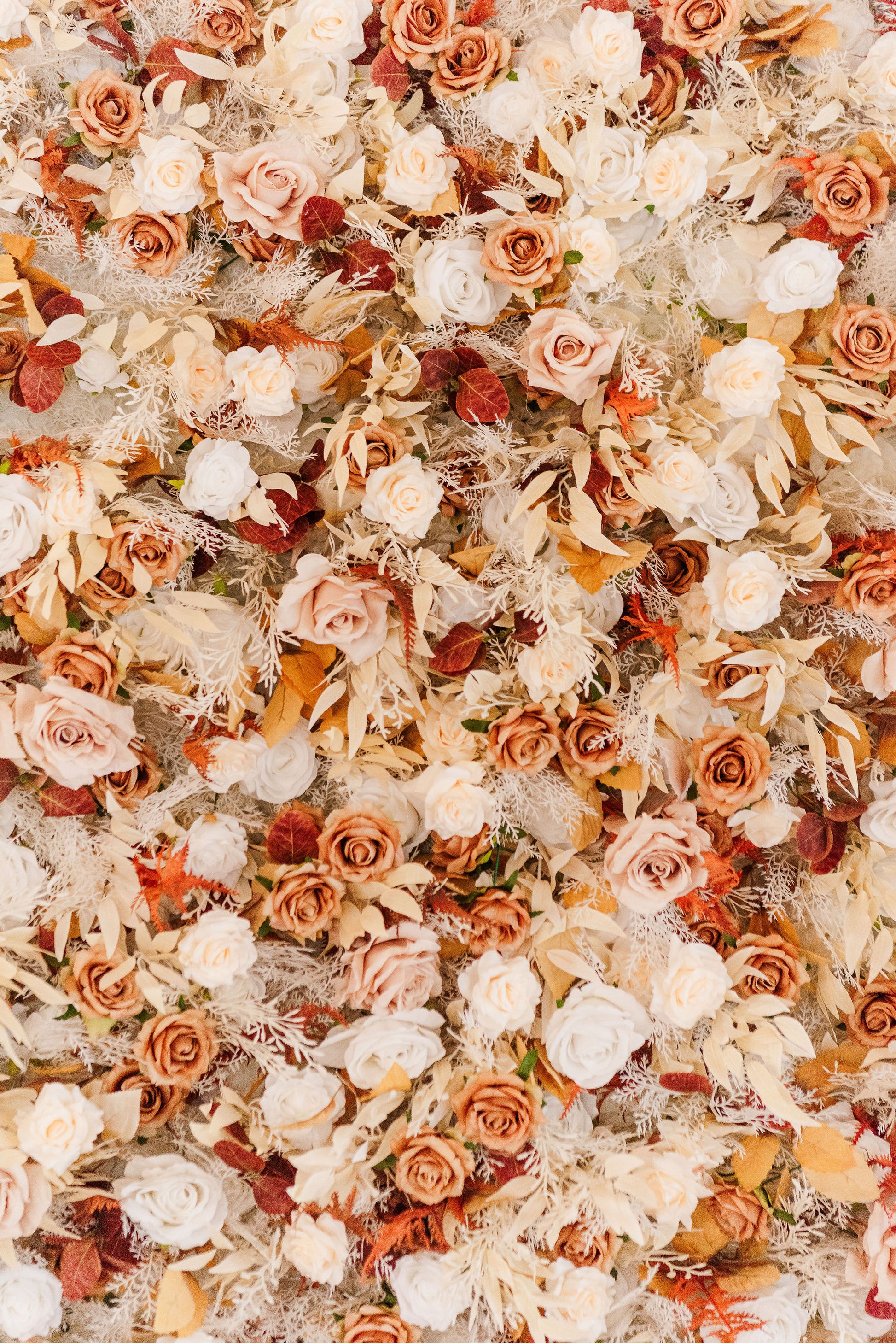 Up-close of the Emmerson flower wall showcasing lifelike roses, ranunculus, and layered with lifelike dried elements to enhance the depth and beauty.