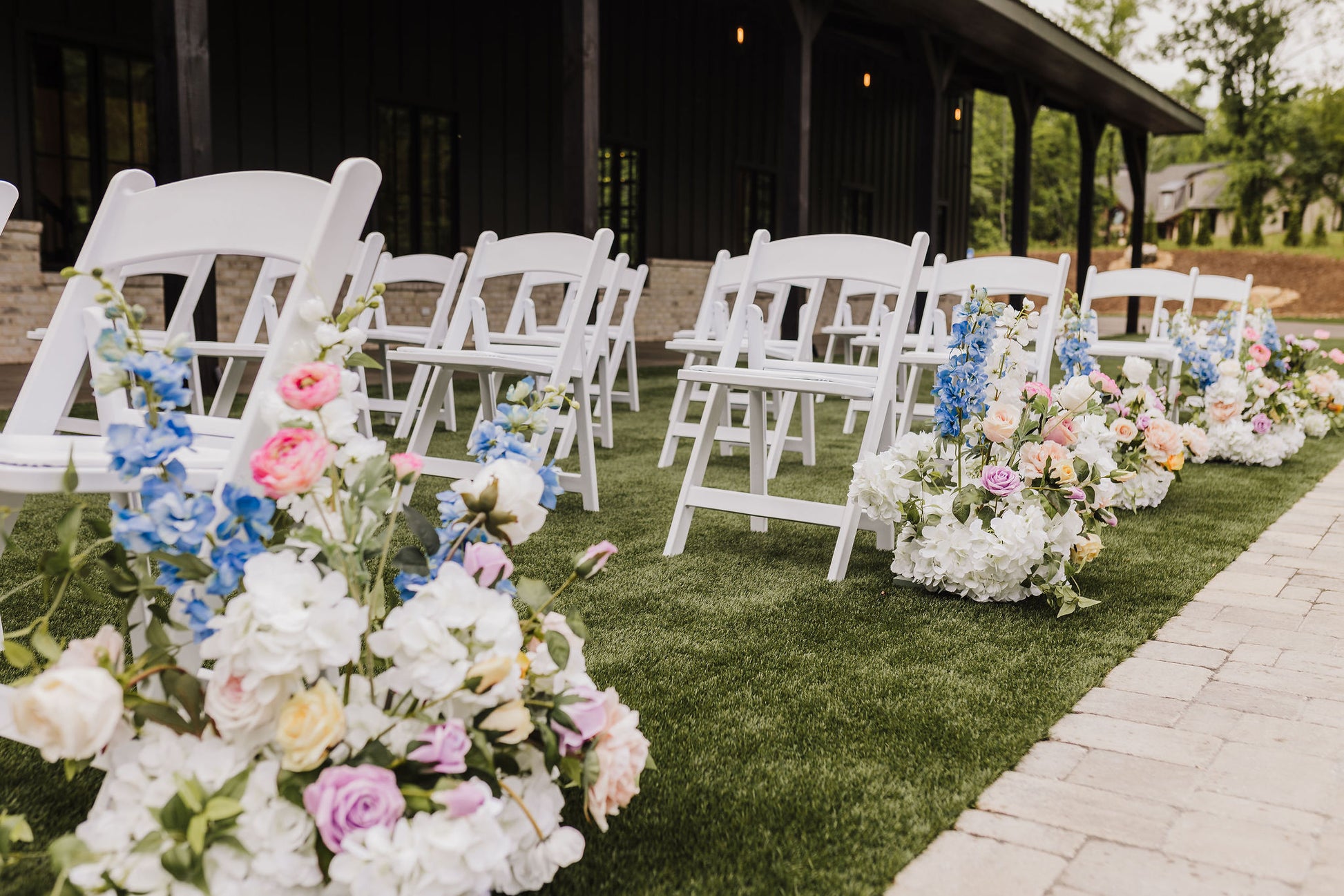 Wildflower aisle bouquets can be repurposed as a reception table arrangement adding rustic charm and cohesive color to the celebration.