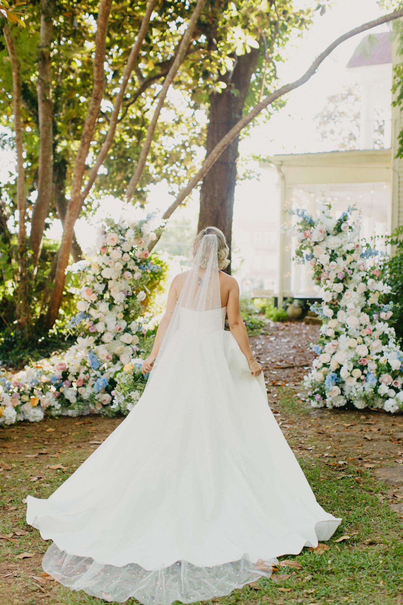 Side view of the wildflower pillars arranged to frame a wedding alter, displaying a loose, organic shape with colorful faux florals.