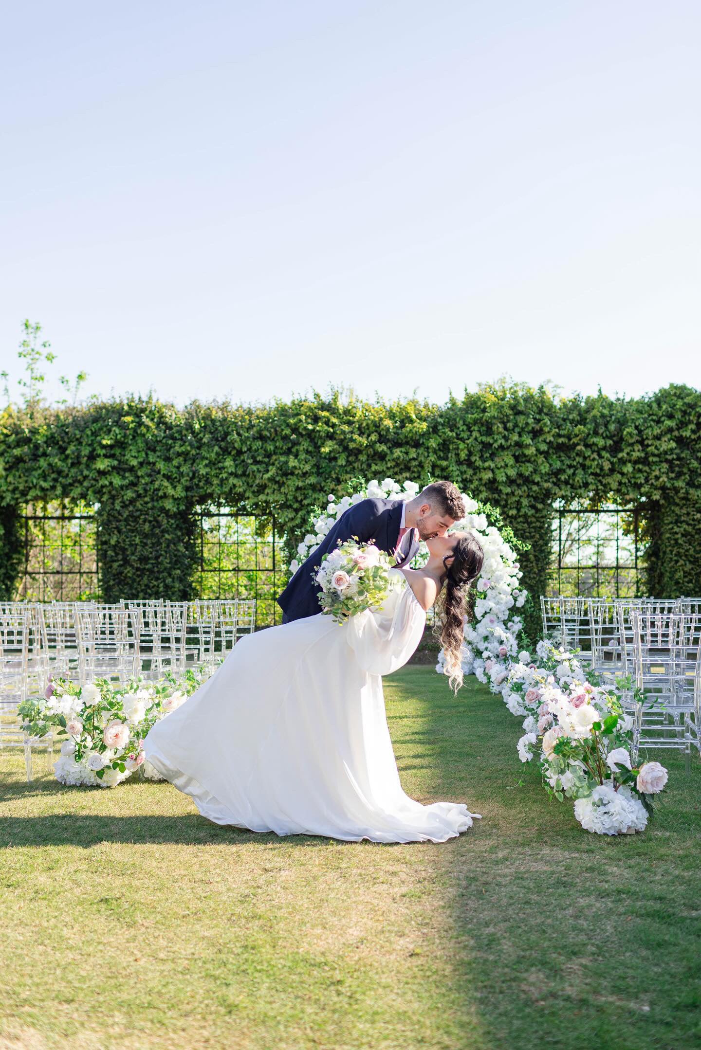 Garden inspired backdrop displaying the Meadow Arch and aisle bouquets.