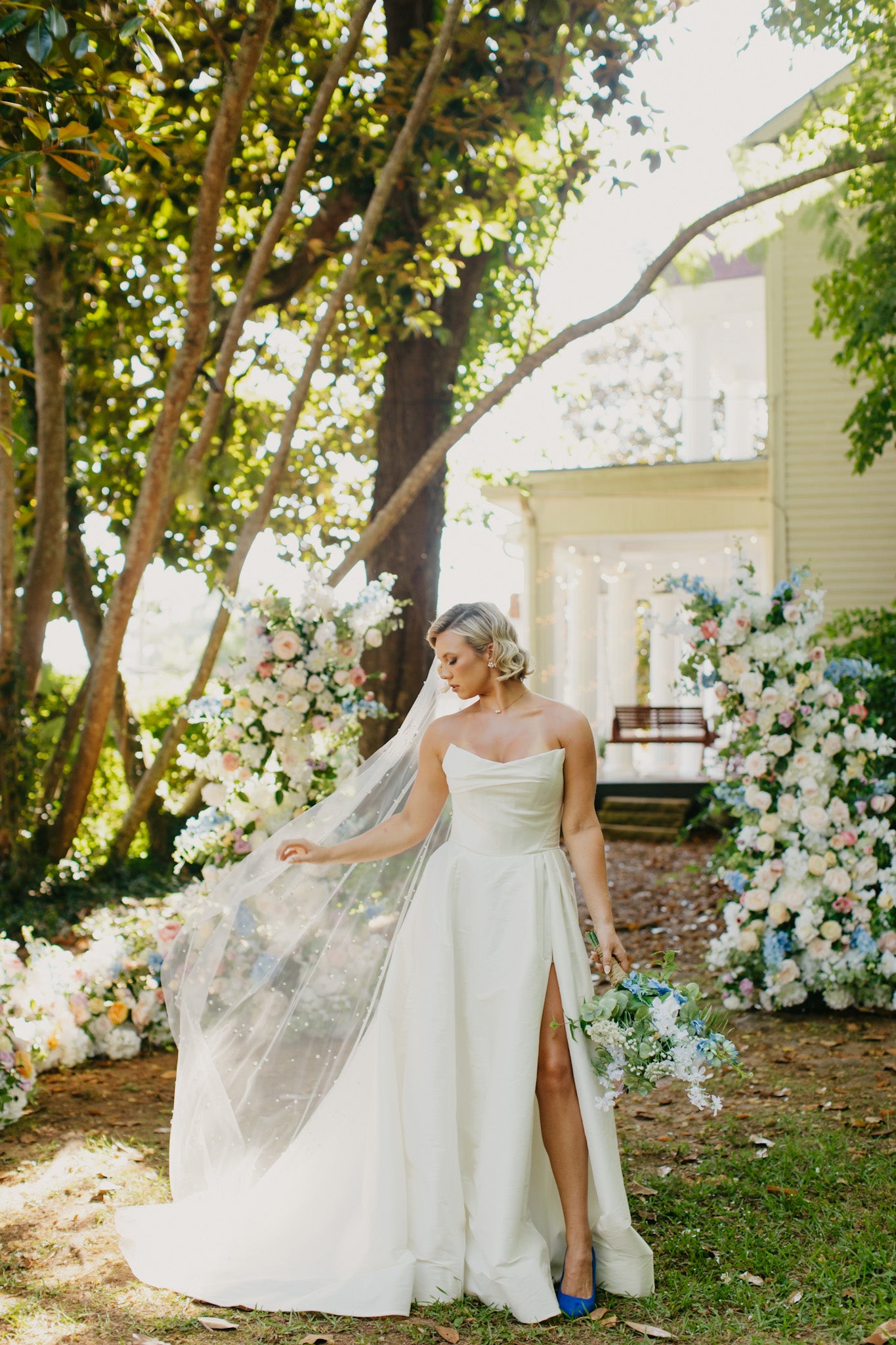 Wildflower pillar arches placed at the top of an outdoor aisle, setting a joyful and playful tone with soft, romantic colors.