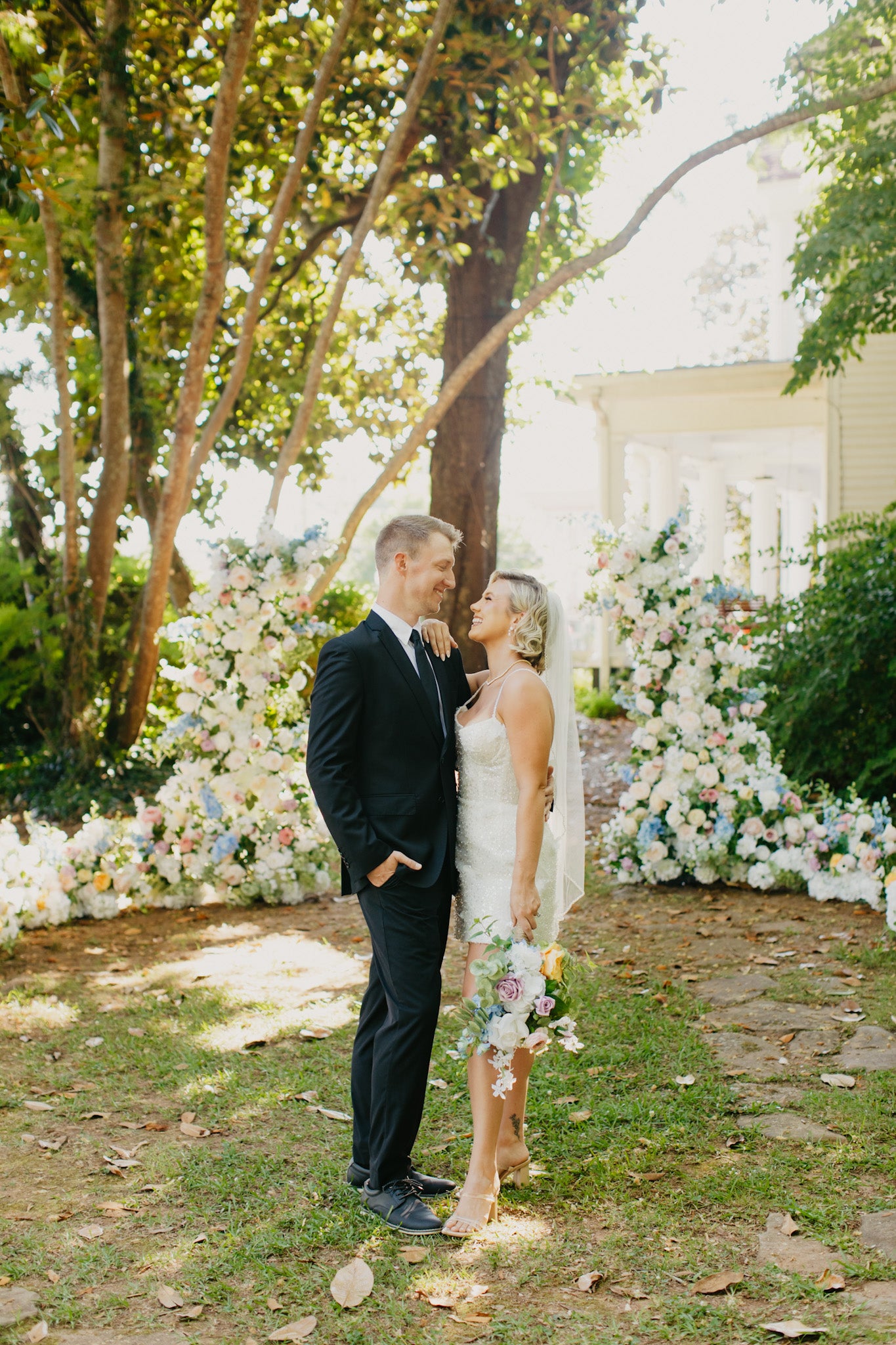 Bride and groom exchanging vows between two vibrant wildflower pillars, surrounded by bright, garden-inspired blooms.