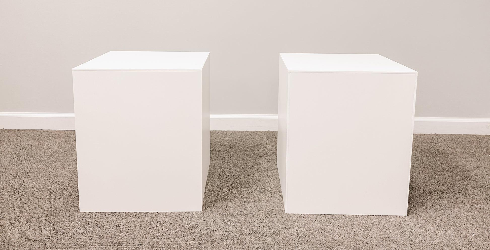 Set of two classic white pedestal stands, perfect for elevating floral arrangements or decor at wedding ceremonies and receptions.