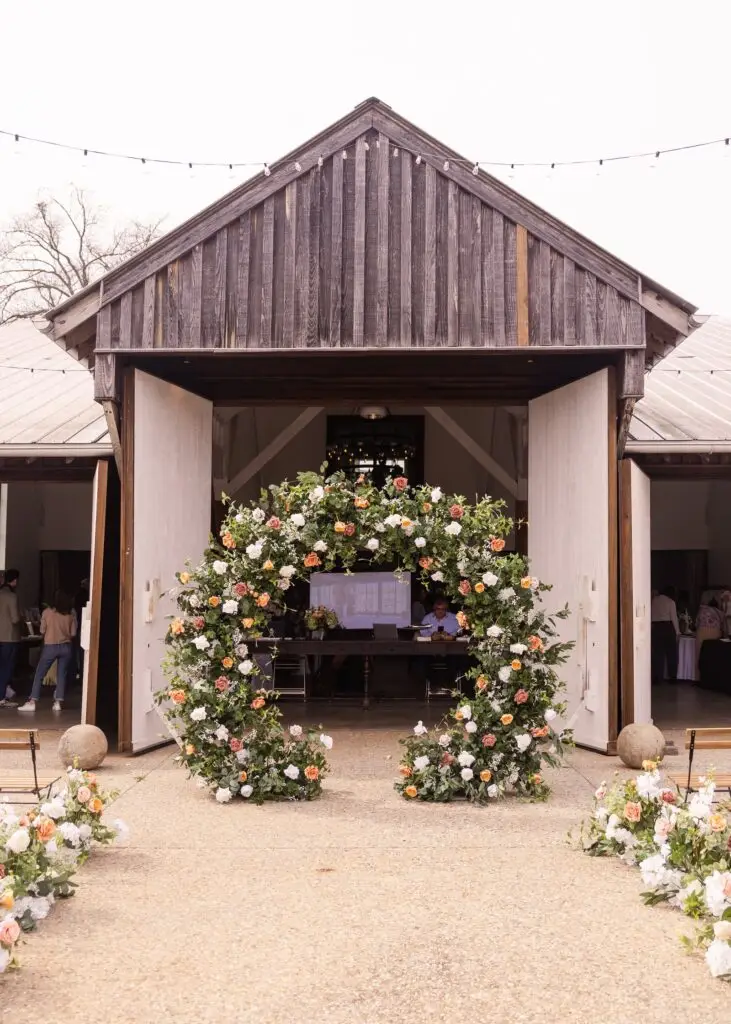 Ever in Bloom circle arch, a floral wedding arch rental in North Georgia, framed in a rustic barn opening